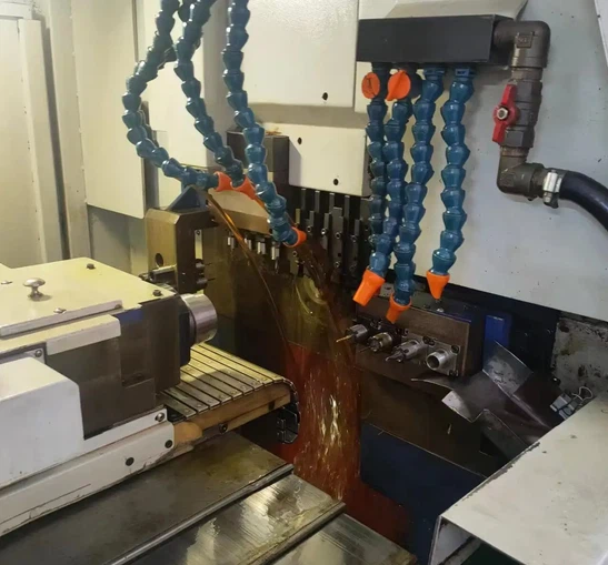 Close-up of a Swiss-type CNC machine cutting a stainless steel slender shaft with high-pressure coolant Close-up of a Swiss-type CNC machine cutting a stainless steel slender shaft with high-pressure coolant
